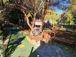 A rustic playground with a sign warning of danger.