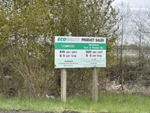 A sign for Eco Waste Product Sales is displayed in a wooded area.