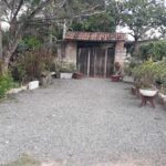 A small patio area with a dirt floor and a small doorway.