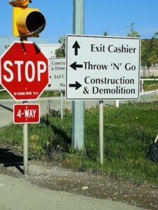 A stop sign is located next to a construction sign.