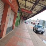 A street with a storefront and a parked car.