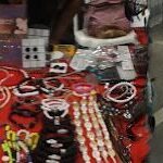 A table full of beads and jewelry, including bracelets, necklaces, and earrings.