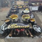 A table full of food, including a variety of dishes and bowls, is set up for a buffet.