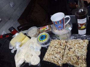 A table full of food items, including nuts, cheese, and a coffee mug.
