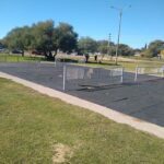A tennis court with a broken net.