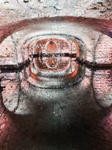 A tunnel with a round opening and a reflection of a light.