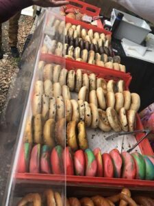 A variety of bagels are displayed in a case, including different flavors and toppings.
