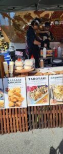 A variety of foods are displayed on a table, including a plate of chicken.