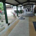 A walkway with a green roof and a yellow floor.
