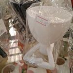 A white cup with a price tag of 16.00 sits on a table.