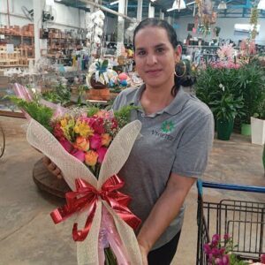 A woman holding a bouquet of flowers in a store.