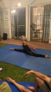 A woman is doing a split on a blue mat.