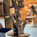 A wooden birdhouse with a tree branch design.