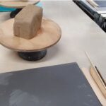 A wooden tray with a loaf of bread on top.