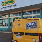 A yellow van with a checkered design is parked in front of a building.