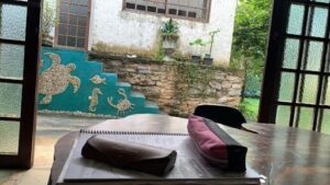 A book with a pink bag on top of it sits on a table.