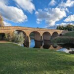 A bridge over a river with a man standing on it.