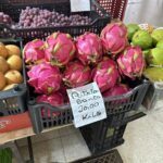 A bunch of pink flowers are on display at a market.