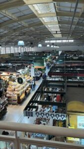 A busy market with people walking around and shopping.