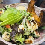 A colorful salad with a variety of vegetables and dressing.