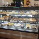 A display case filled with a variety of desserts, including cakes and cookies.