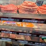 A display case filled with various types of sausages and meats, including limescale and chorizo.