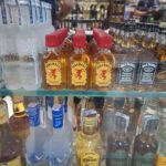 A display of alcoholic beverages, including Fireball whiskey and Jack Daniels, sits on a shelf.