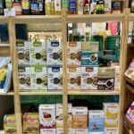 A display of various food items, including cookies, cereal, and other snacks, is arranged on a shelf.