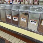 A display of various grains and beans, including rice, beans, and peanuts, are available for purchase.