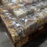 A display of various snacks and candies in plastic containers.