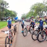 A group of bicyclists are lined up on a road, ready to race.