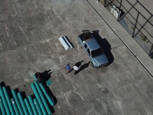 A group of men are standing in a parking lot, looking at a truck.