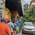 A group of people are standing in line outside a building, waiting to enter.