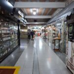 A group of people walking down a hallway in a shopping mall.