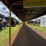 A group of trucks are parked under a yellow canopy.