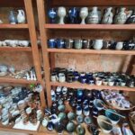 A large collection of blue and white pottery is displayed on wooden shelves.