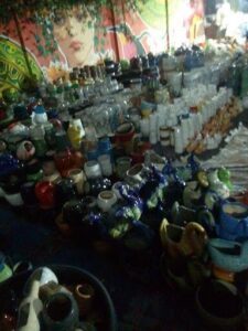 A large collection of vases and cups are displayed on a table.
