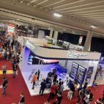 A large group of people are gathered in a building, likely at a convention or event.