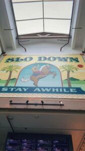 A large sign that says "Slow Down" is displayed on a building.