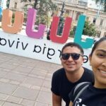 A man and woman pose for a picture in front of a sign that says "Pipi".