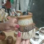 A person holding a coffee mug with a spoon in it.