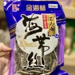 A person is holding a bag of seaweed.