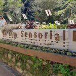 A sign for the Sensory Garden is displayed on a wall.