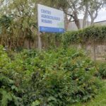 A sign in a garden with the words "Centro Agricola Rosario" written on it.