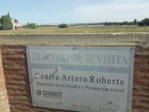 A sign in Spanish reads "Centro Arturo Roberts" and is located in front of a building.