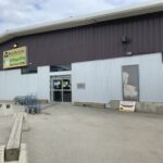 A sign is posted in front of a building that says "Bowling Supply Open."