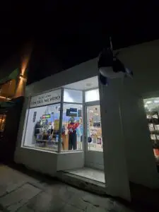 A storefront with a black and white sign that reads "Fin del Mundo."
