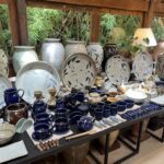 A table full of blue and white pottery, including cups, bowls, and vases.