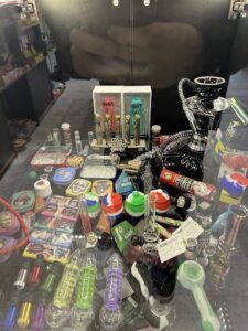A table full of various items, including a box of cigarettes, a pipe, and a lighter.