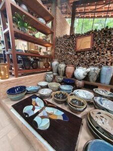A variety of colorful vases and bowls are displayed on a table, creating an eye-catching and vibrant display.